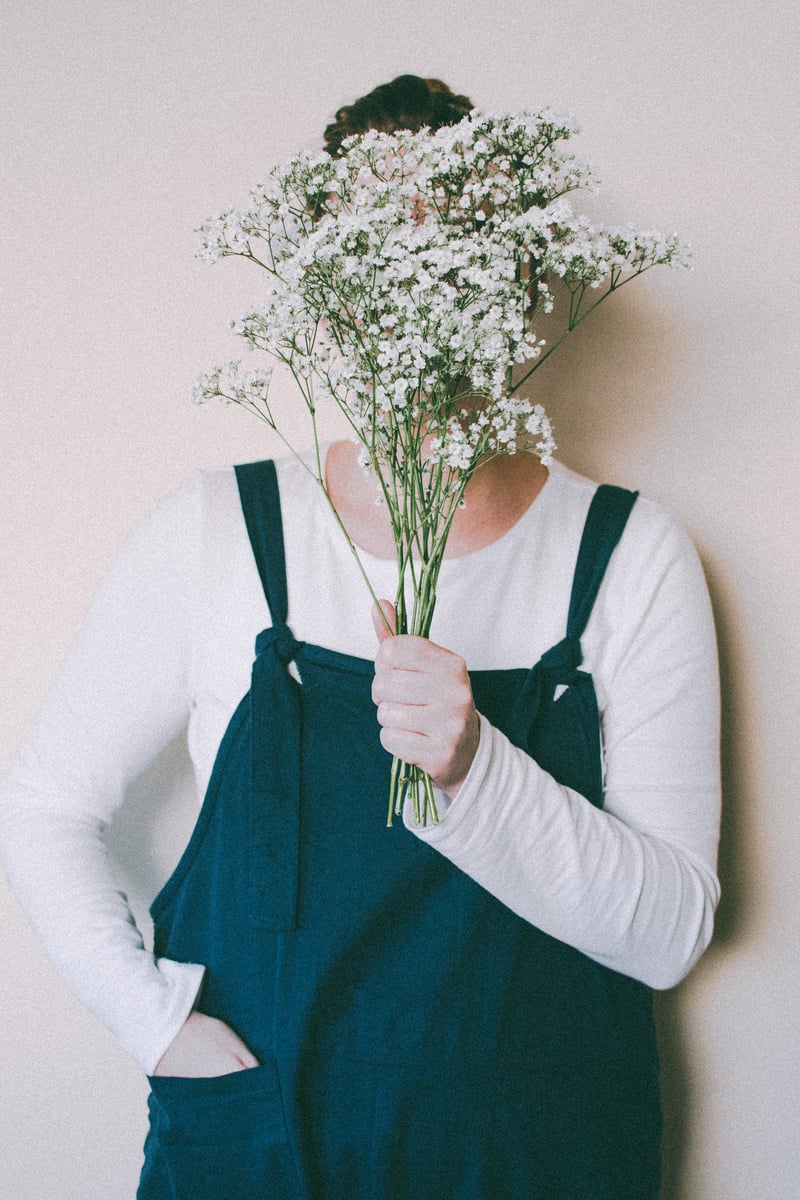 Person Hiding Face With Flowers